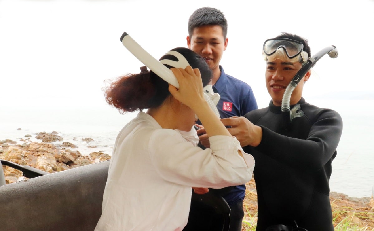 Instructors provide diving equipment and explain safety regulations to guests.